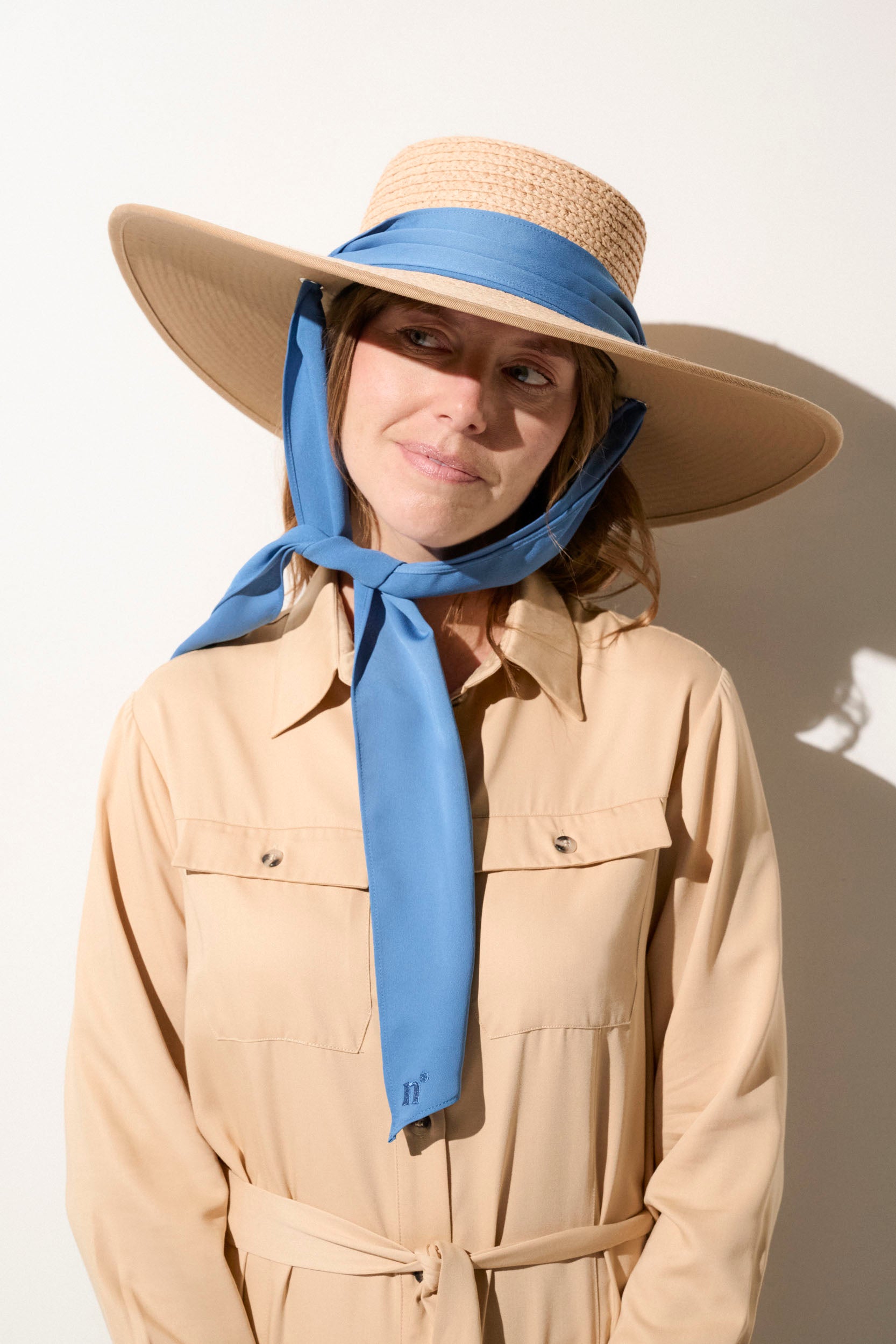 Chapeau anti-UV pour femme, style élégant avec ficelle bleue, idéal pour protection solaire en été.