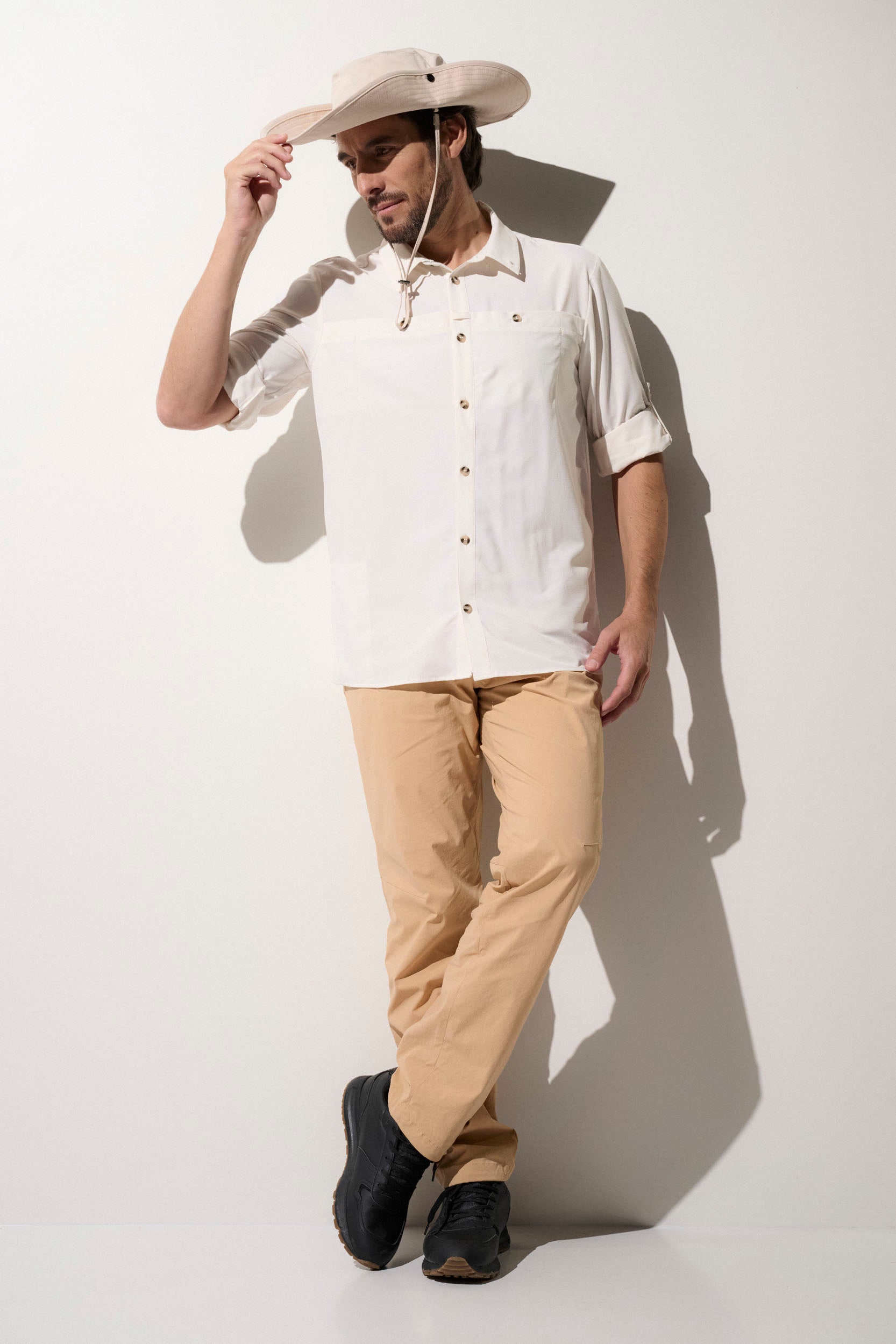 Homme portant un chapeau anti-UV beige et une chemise légère, élégante, UPF50+, idéale pour outdoor.