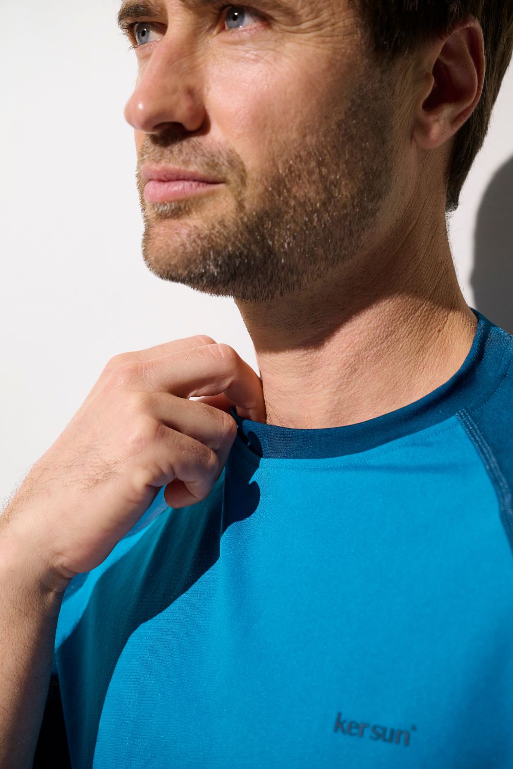 Homme portant un t-shirt de bain anti-UV bleu UPF 50+, élégant et léger, signé Ker Sun.