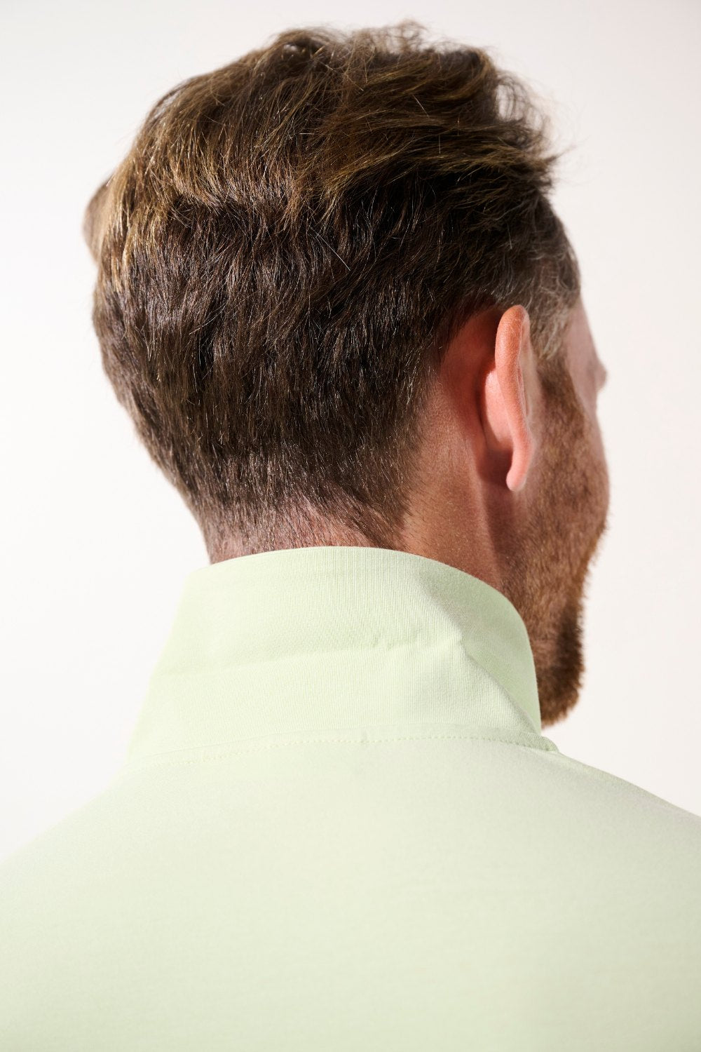 Polo anti-UV - Saint-Malo en vert pâle porté par un homme, avec col montant pour une protection solaire élégante.