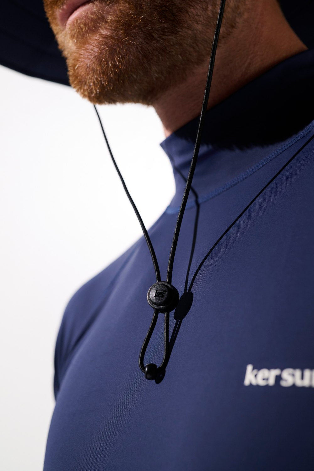 Chapeau de bain anti-UV - Galápagos porté par un homme en maillot UPF 50+, idéal pour la protection solaire.