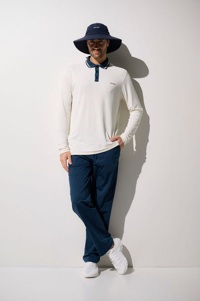 Homme portant un polo anti-UV Augusta UPF 50+ et un chapeau, confortable et léger, idéal pour le plein air.