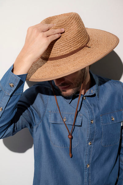 Homme portant un chapeau anti-UV en paille, idéal pour se protéger du soleil avec UPF 50+.