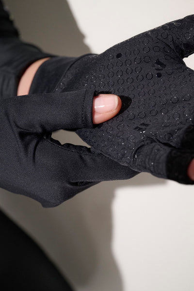 Mitaines anti-UV noires UPF50+ pour femme, conçues pour le confort et l'adhérence pendant les activités aquatiques.