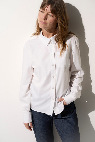 Chemise anti-UV blanche UPF50+ pour femme, élégante et confortable, idéale pour les journées ensoleillées.