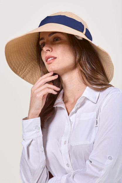 Femme portant un chapeau anti-UV à bord large, de couleur beige et certifié UPF 50+