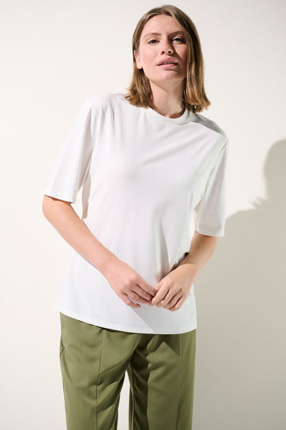 T-shirt anti-UV blanc pour femme, léger et élégant, UPF 50+, parfait pour une journée ensoleillée.