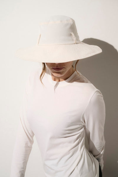 Chapeau anti-UV blanc UPF 50+ porté par une femme, idéal pour une protection solaire élégante au quotidien.