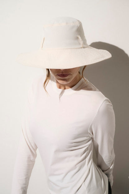 Chapeau anti-UV blanc UPF 50+ porté par une femme, idéal pour une protection solaire élégante au quotidien.