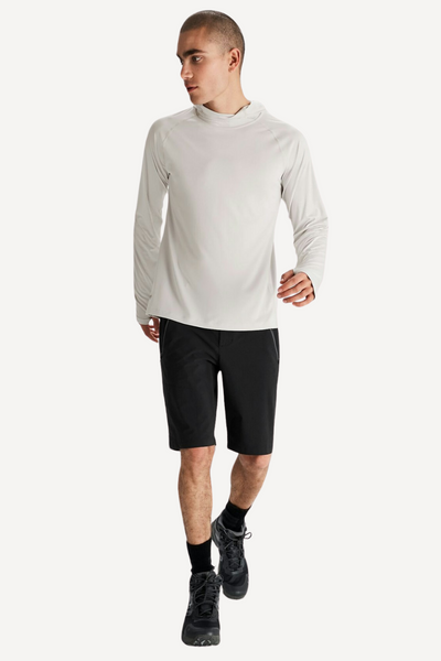 Homme en sweat anti-UV blanc avec capuche, manches longues et short, parfait pour le sport en extérieur.